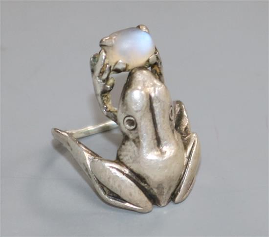 A white metal and moonstone set frog ring, size P/Q.